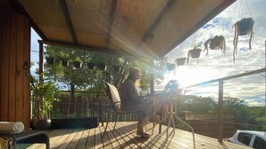 A wooden deck with a hot tub, potted plants, and a view of the sky. - Chalet with hot tub: water directly from the Bridal Veil Waterfall heated to 40°C. (Santana do Riacho)