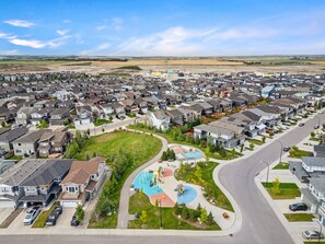 A residential area with houses, a playground, and a curved road. - Northbound | Modern | Fast WiFi | 10-Foot Ceilings (Calgary)