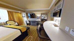 A hotel room with a bed, a desk, a chair, a TV, and a kitchenette. - Luxury Experience-4BR Villa-10 people-Las Vegas Resort & Casino-Ideal for Groups (Las Vegas)