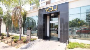 Un edificio moderno con fachada de vidrio y un letrero que dice "YOU LifeStyle".