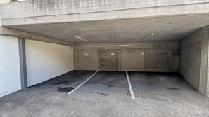 Eine Parkgarage mit Betonwänden, ebener Decke und eingezeichneten Parkplätzen.