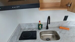 A modern kitchen with a built-in stove, a sink, and a drawer with utensils. - Tu espacio en Col Americana y AV Chapultepec (Guadalajara)