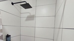 A shower area with a glass door, a handheld showerhead, and a soap dispenser. - Tu espacio en Col Americana y AV Chapultepec (Guadalajara)