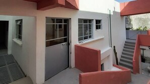 Ein Gebäude mit rotem und weißem Anstrich, einer Treppe und einem Fenster.