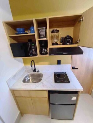A compact kitchen with a sink, a coffee maker, a blender, and a toaster. - Toledo Suite en chapultepec U3 (Guadalajara)