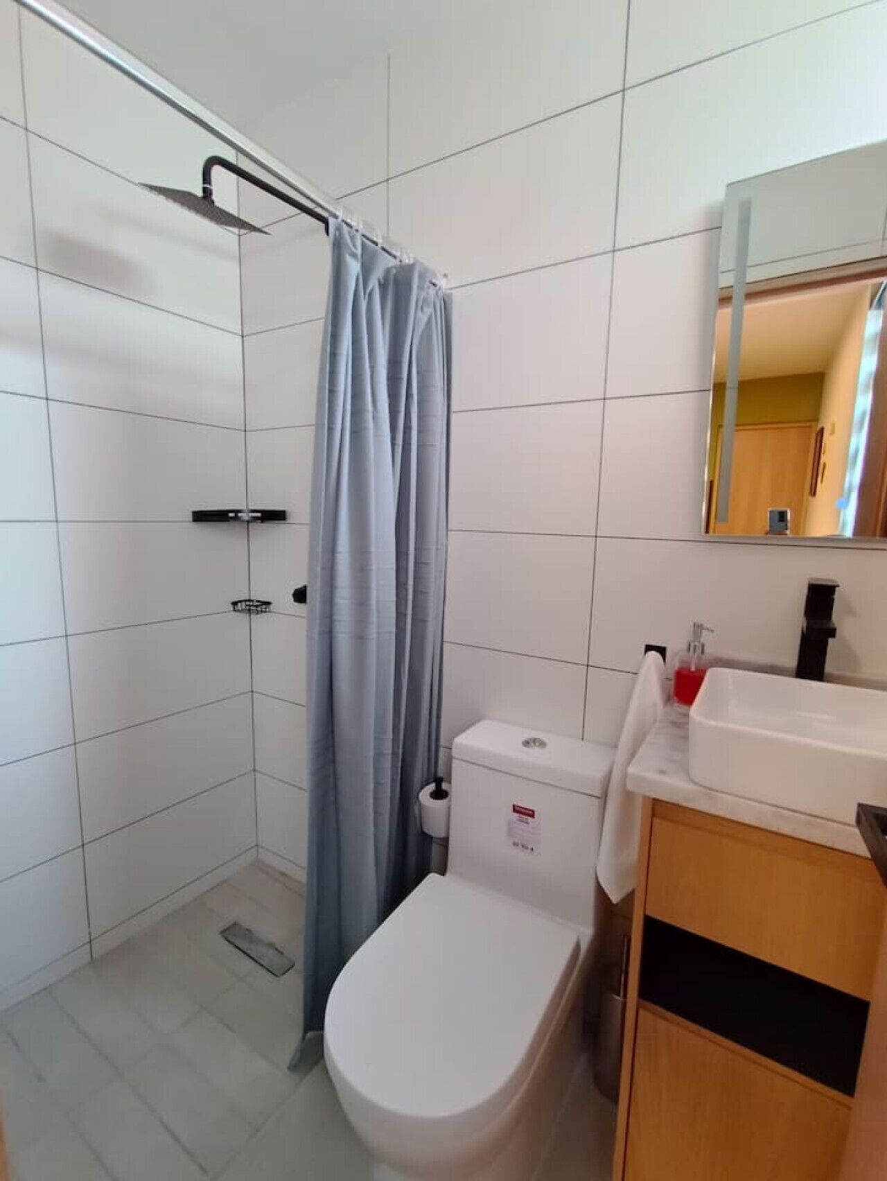 Ein Badezimmer mit Dusche, Toilette und Waschbecken.