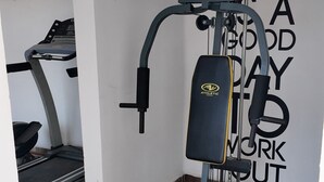 A home gym with a treadmill, weight bench, and exercise equipment. - Depa cerca del Paseo Bravo (Puebla)