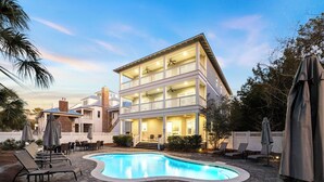 A two-story building with a swimming pool, outdoor seating, and a covered patio area. - Walk to Seaside, Beach! Private Pool & LSV! Sleeps 24, PETS OK! (Santa Rosa Beach)