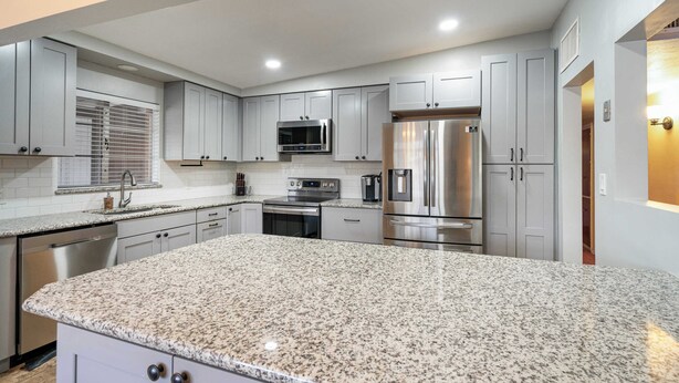 A modern kitchen with granite countertops, stainless steel appliances, and light gray cabinetry. - Central Tucson Gem w/ Porch, Patio & Park Access (Tucson)