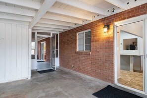 Ein Korridor mit Backsteinwand, Glastür und weißer Decke.