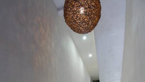 Una moderna scala con pareti bianche e un lampadario dal soffitto strutturato.