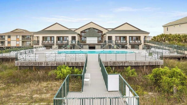 Ett hotell med en pool i mitten, en överbyggd gångväg och utsikt över det omgivande landskapet.