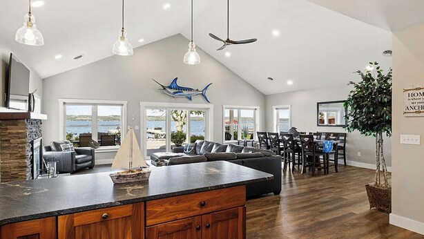 A spacious living area with a large island, dark wood cabinets, and a view of the outdoors. - Mott's Lakefront Landing: Dog-Friendly Lakefront Escape on Seneca Lake! (Lodi)