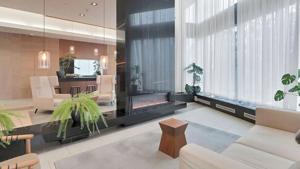 Ein modernes Wohnzimmer mit Kamin, Sitzecke und großen Fenstern.