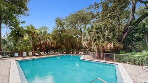 A rectangular swimming pool with a metal ladder, surrounded by lounge chairs and palm trees. - Colorful 3-Bedroom Dog-Friendly Condo Near the Ocean, Fernandina Beach (Fernandina Beach)