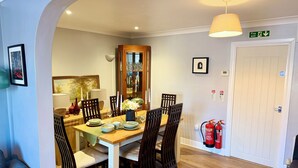 A dining area with a wooden table, chairs, and a fire extinguisher.