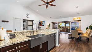 Una cocina amplia con una isla grande, un comedor con vistas y un ventilador de techo.
