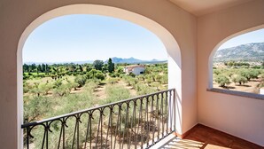 A balcony with a wrought iron railing overlooking a rural landscape with trees and a building. - 1 bedroom gorgeous apartment in Orosei (Orosei)