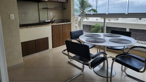 Una cucina moderna con piano cottura integrato, mobili in legno e un'ampia finestra che offre vista su palme e sullo skyline della città.