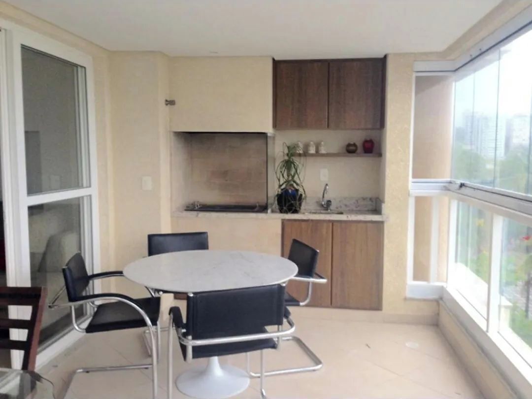 A compact kitchen with a dining area, a window, and a view of the city.