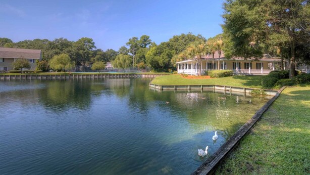 Un paesaggio tranquillo sul lago, con un gazebo e un edificio con veranda.