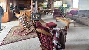 A spacious living area with a high ceiling, wooden beams, a fireplace, and a cozy seating arrangement. - Amazing Country Farm in charming Del Norte perfect for large groups and families (Del Norte)