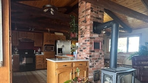 A rustic kitchen with wooden cabinets, a brick chimney, and a large stove. - Amazing Country Farm in charming Del Norte perfect for large groups and families (Del Norte)