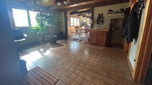 A spacious kitchen with wooden cabinets, a dining area with a table and chairs, and a large window providing natural light. - Amazing Country Farm in charming Del Norte perfect for large groups and families (Del Norte)