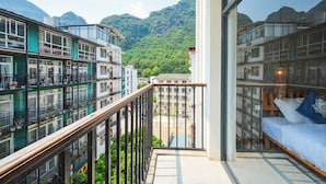 A balcony with a view of a mountain and adjacent buildings. - Morning Sun Hotel (Guilin)