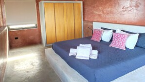 A bedroom with a large bed, a wooden wardrobe, and a whiteboard on the wall. - Ideal cottage to rest with the family very close to the sea, one pet is accepted. (El Sargento)