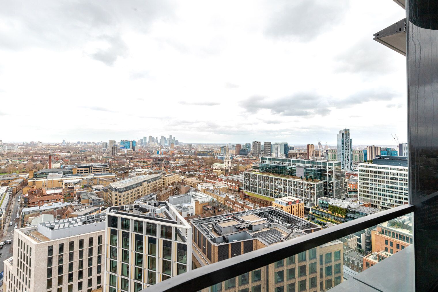 A high-rise building with a view of a cityscape, featuring modern architecture and a mix of residential and commercial buildings.