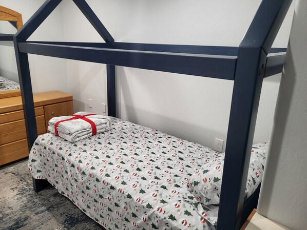 A bunk bed with a white bedspread featuring Christmas-themed designs, a wooden dresser, and a dark blue metal frame. - Magical 10+ Acres w/4-bed, 4-bath VILLA Retreat in Beautiful Foresthill (Foresthill)