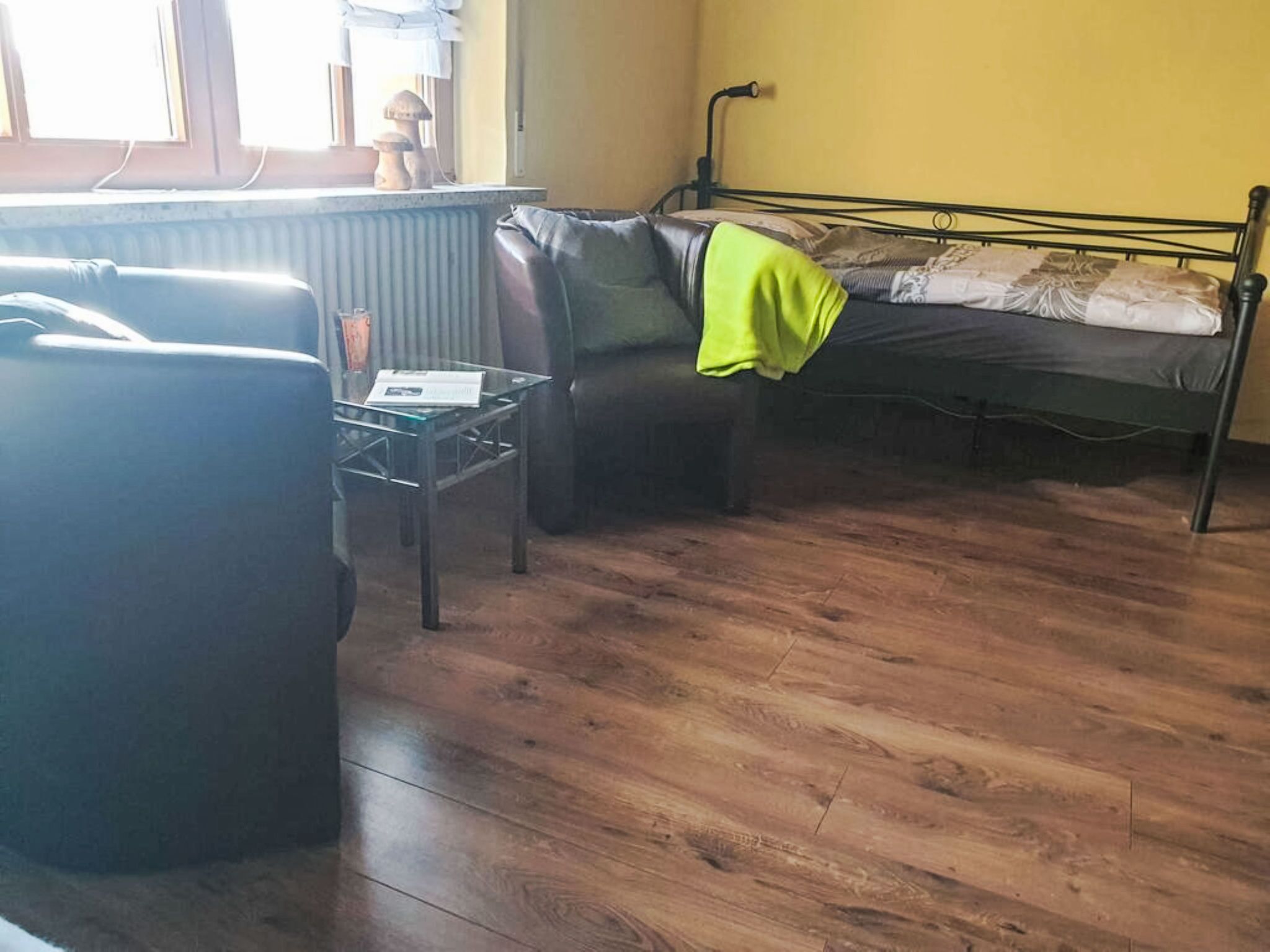 Ett rum med en säng, en soffa och ett litet bord.