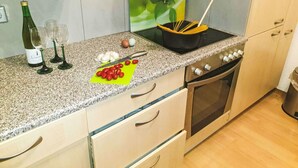 A kitchen with a granite countertop, a stove, and a sink.