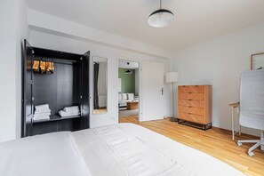 Een moderne hotelkamer met een bed, een kledingkast, een dressoir en een bureau.