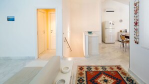A modern kitchen with a white refrigerator, a small island, and a dining table with chairs. - Beautiful private villa for 6 people with A/C, WIFI, private pool, TV, veranda and panoramic view (Cornino)