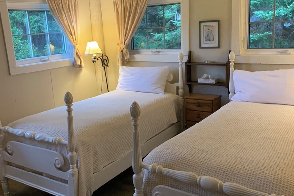 Barn 2 with two single beds. This corner room has four windows, a ceiling fan and a refrigerator