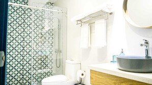 Een badkamer met douche, toilet, wastafel en handdoekrek.