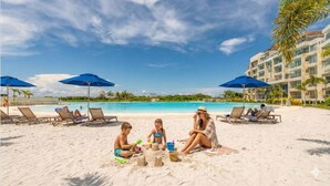 Ein Strand mit Pool, Liegestühlen und Sonnenschirmen.