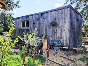 A rustic wooden building with a wooden fence, a wheel, and a birdhouse. - Tiny House Cottage Herbert by Interhome (Grossschönau)