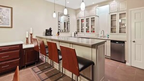 Une cuisine moderne dotée d’un îlot central, de tabourets de bar et d’un lave-vaisselle.