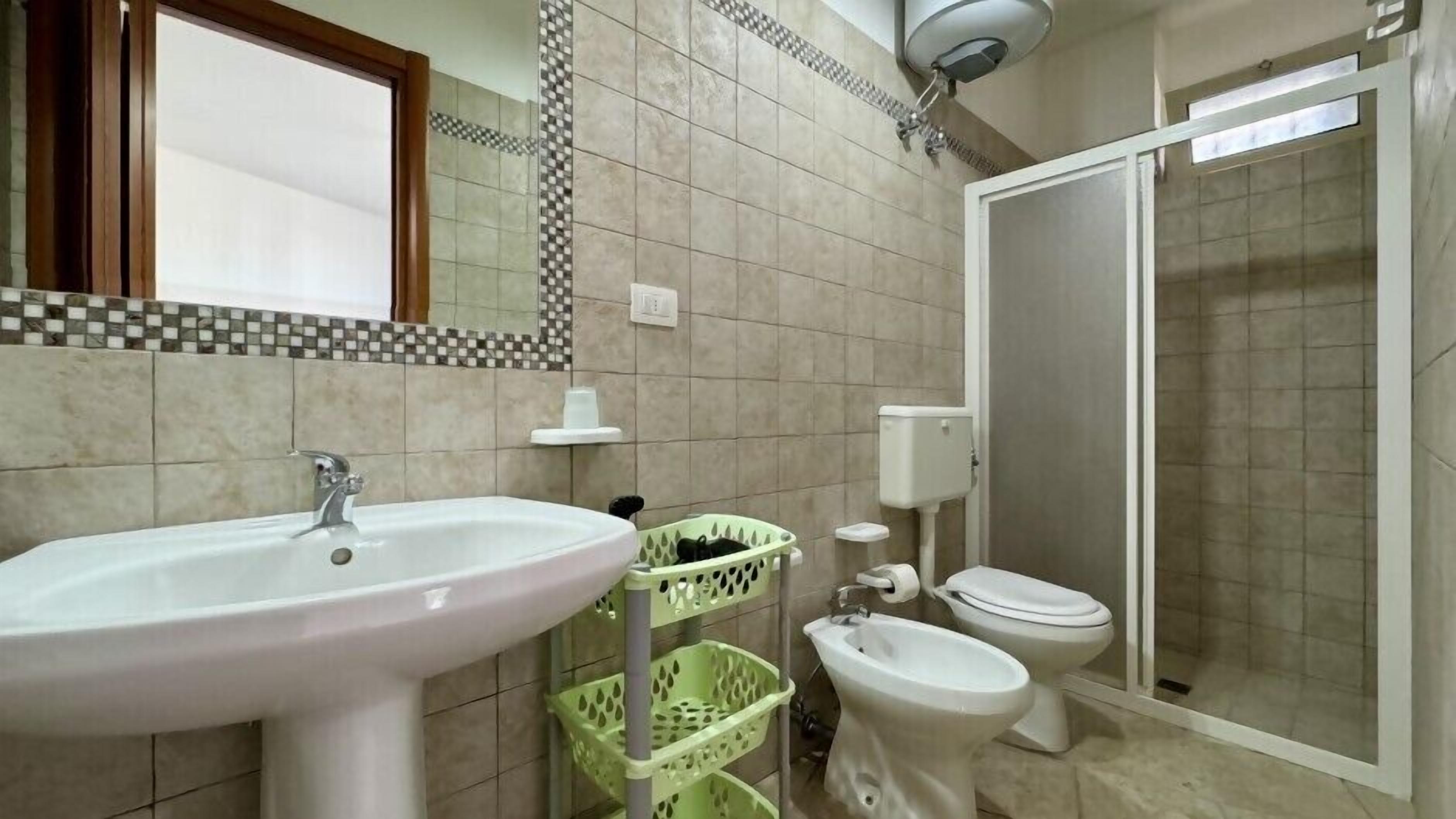 Une salle de bain équipée d’un lavabo, d’un bidet, de toilettes et d’une douche.