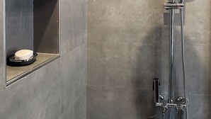 Eine moderne Dusche mit Handbrause und Deckenregenbrause.