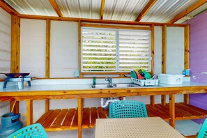 Fridge, stovetop, coffee/tea maker, cookware/dishes/utensils - Rustic overwater cabin with oceanfront deck, island kitchen & sea breeze views (Placencia)