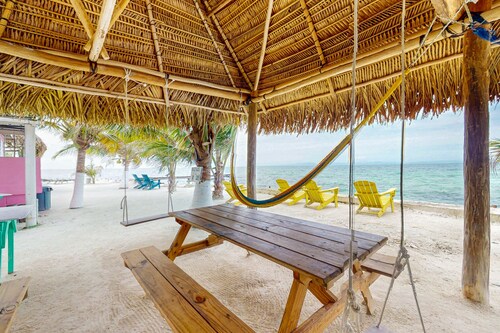 Rustic overwater cabin with oceanfront deck, island kitchen & sea breeze views