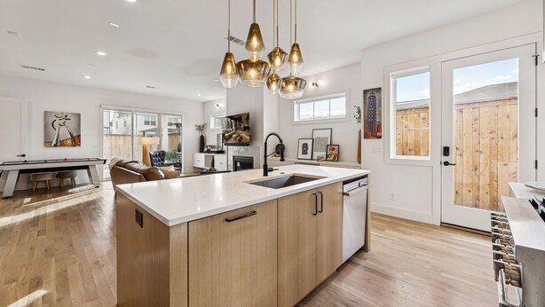 A modern kitchen with a central island, wooden cabinets, and pendant lighting. - Prime World Cup Access • Sleeps 8 - 10 • New Luxury Build (Dallas)