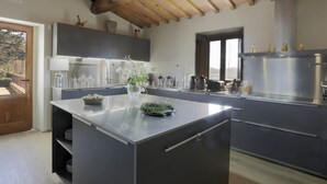 Una cocina moderna con una isla central, electrodomésticos de acero inoxidable y vistas al exterior.