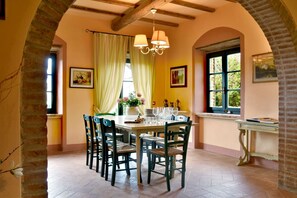 A dining area with a table set for four, surrounded by chairs, a chandelier, and artwork on the walls. - VILLA  LARA - VILLA LARA (Guardistallo)