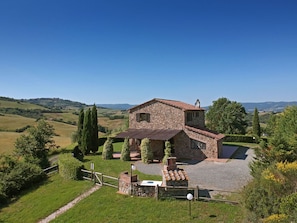 A stone house with a sloped roof, surrounded by a well-maintained garden and a gravel driveway. - VILLA  LARA - VILLA LARA (Guardistallo)