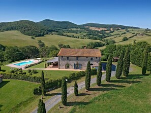 A stone villa with a tiled roof, a swimming pool, and a well-maintained garden with cypress trees. - Magnificent stone house 10 km from the sea with solarium and heated pool. (Guardistallo)